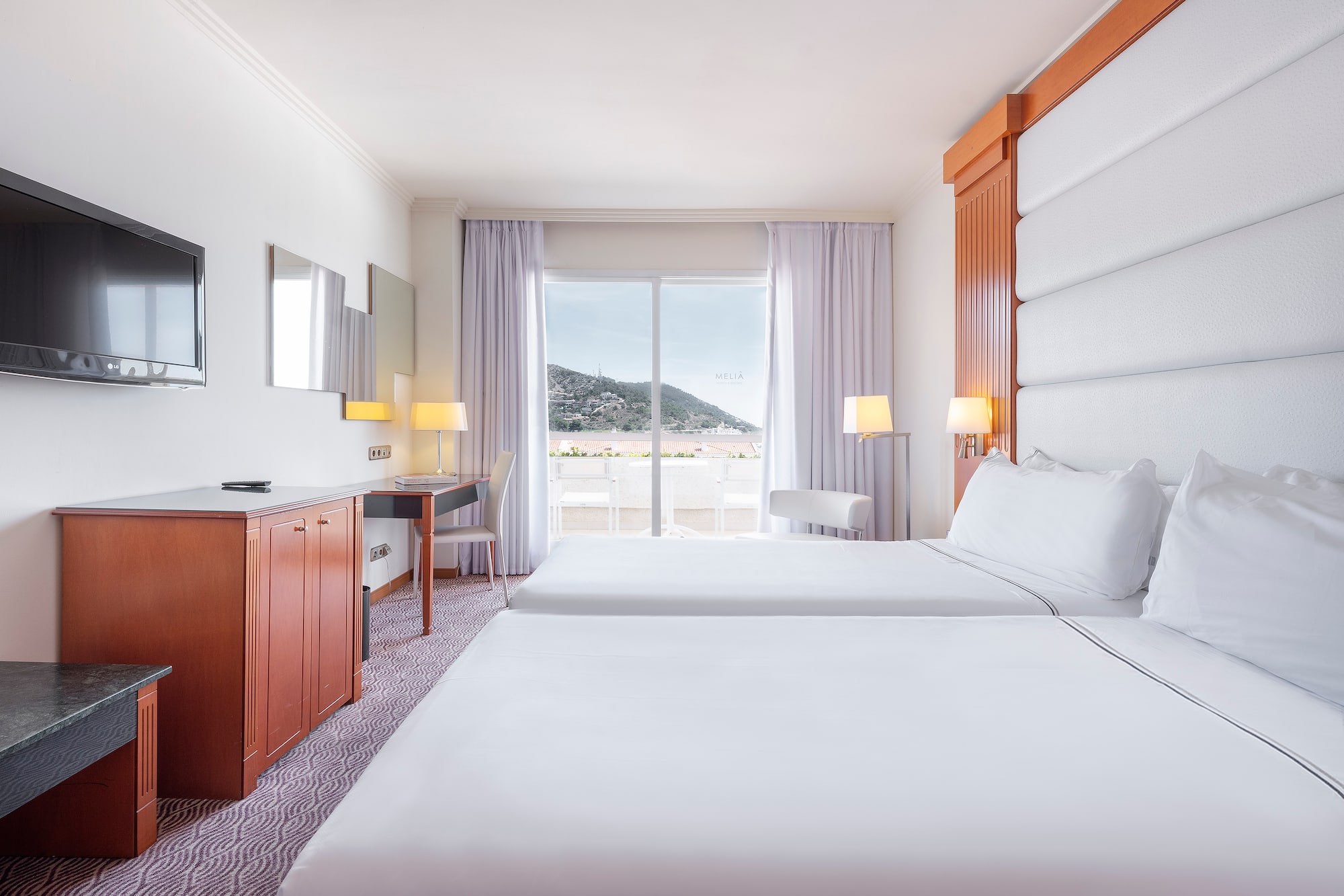 a room with two beds and a television