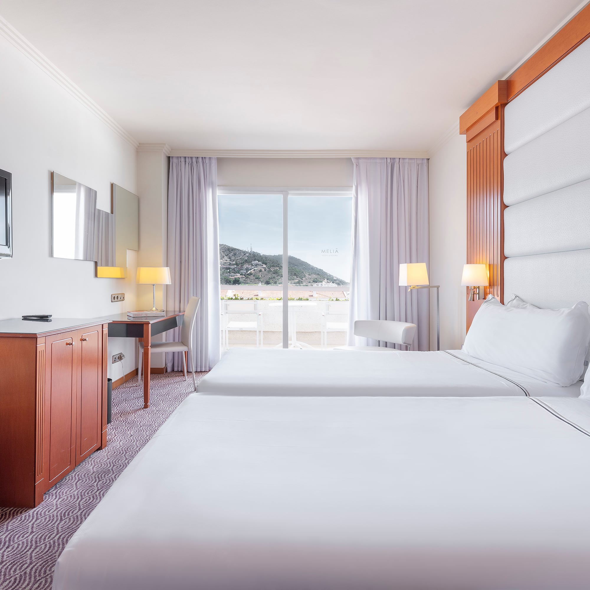 a room with two beds and a television