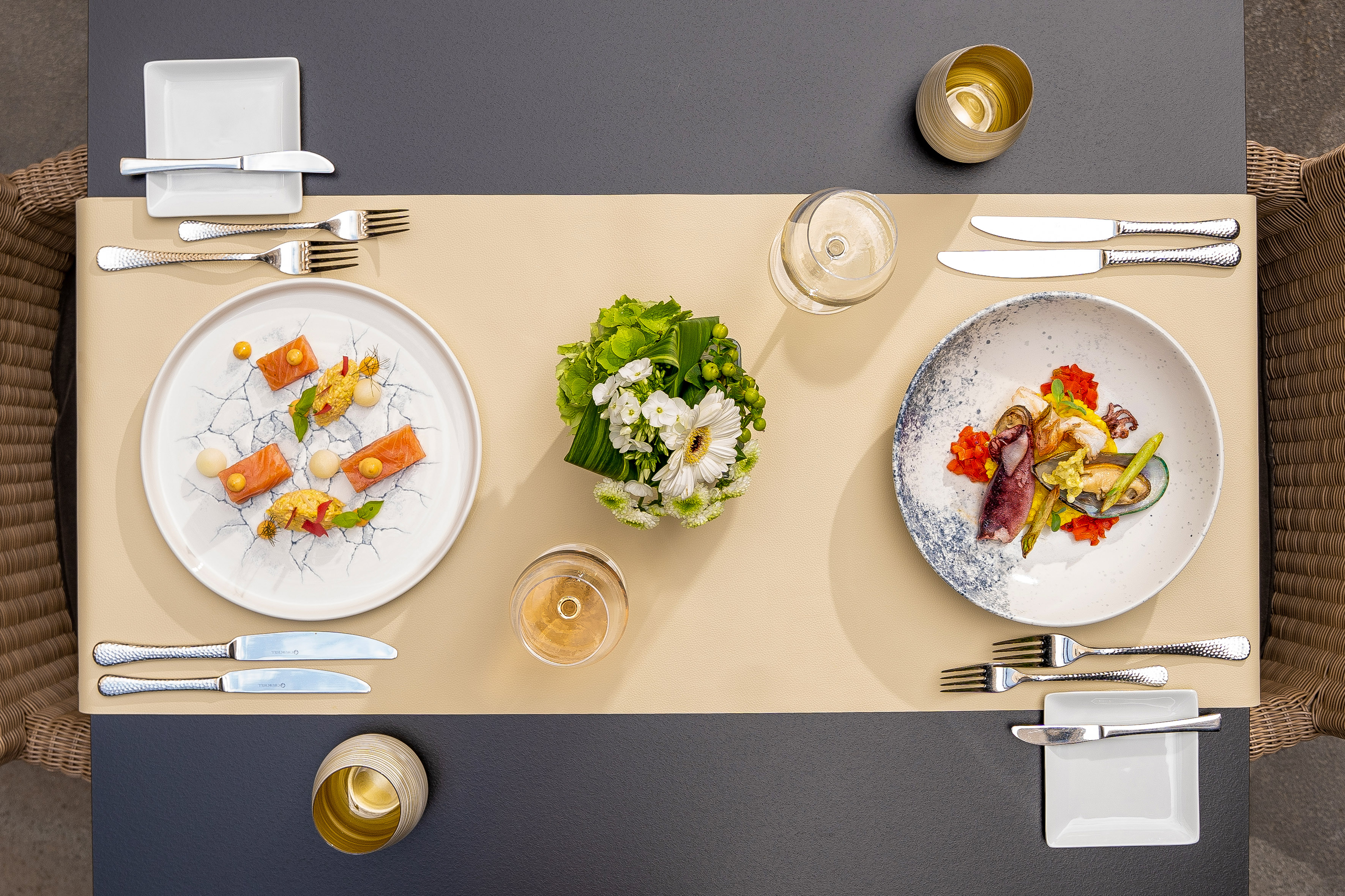 Gourmet fine dining with salmon and seafood, wine, floral centerpiece.