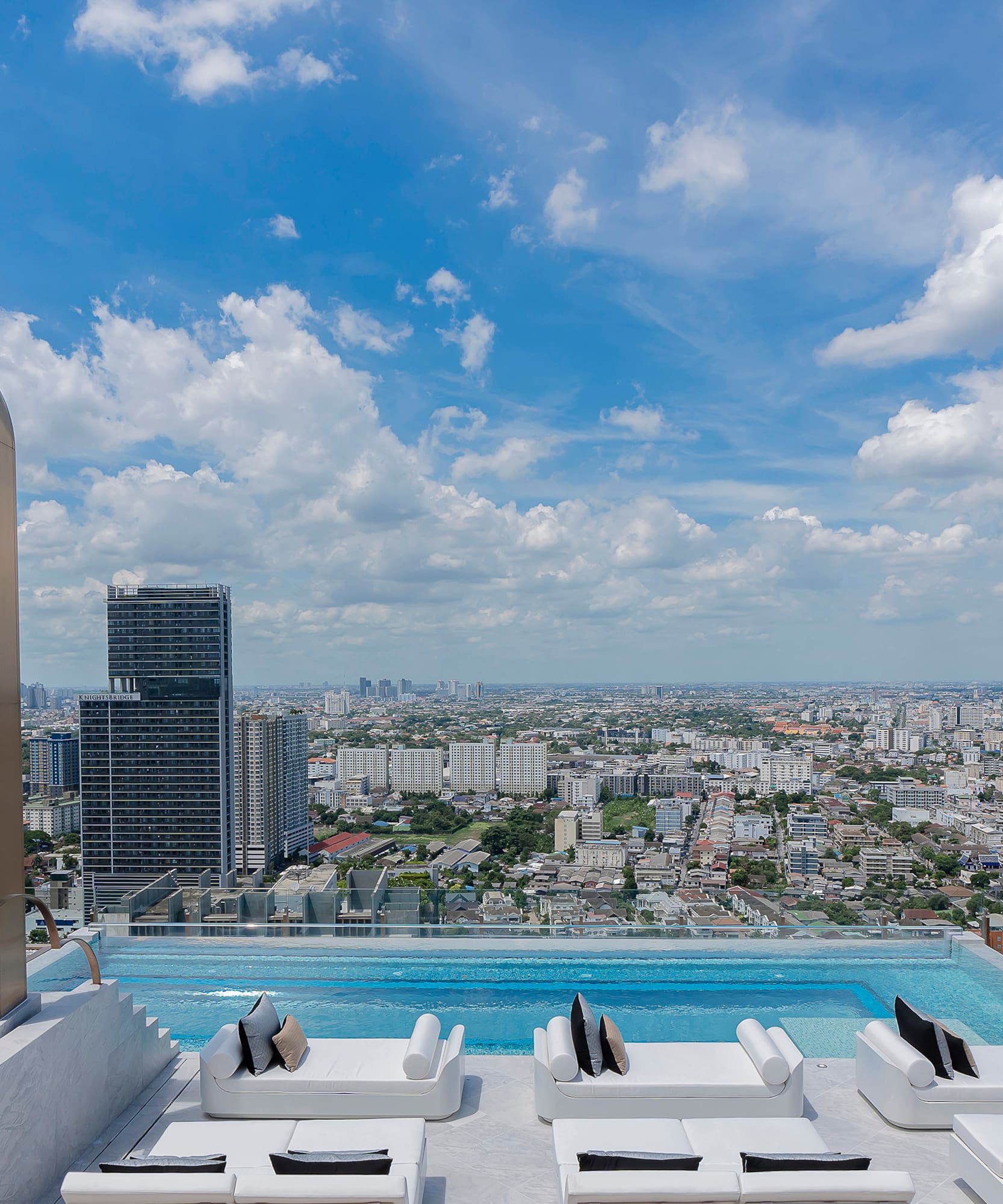 a pool with a view of a city and a blue sky