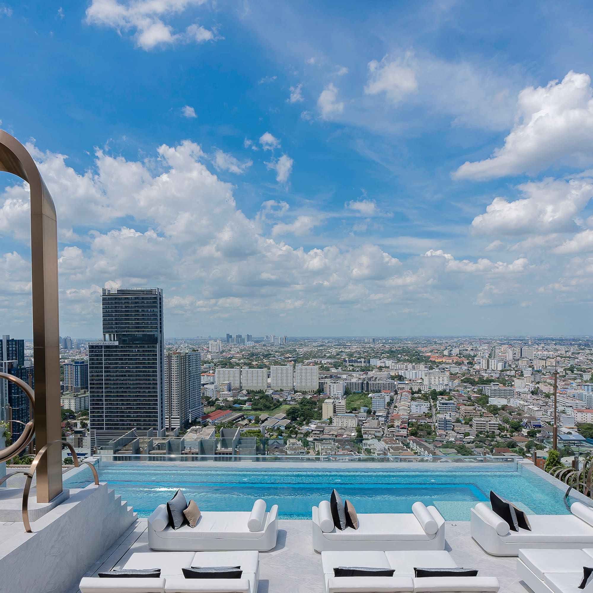 a pool with a view of a city and a blue sky