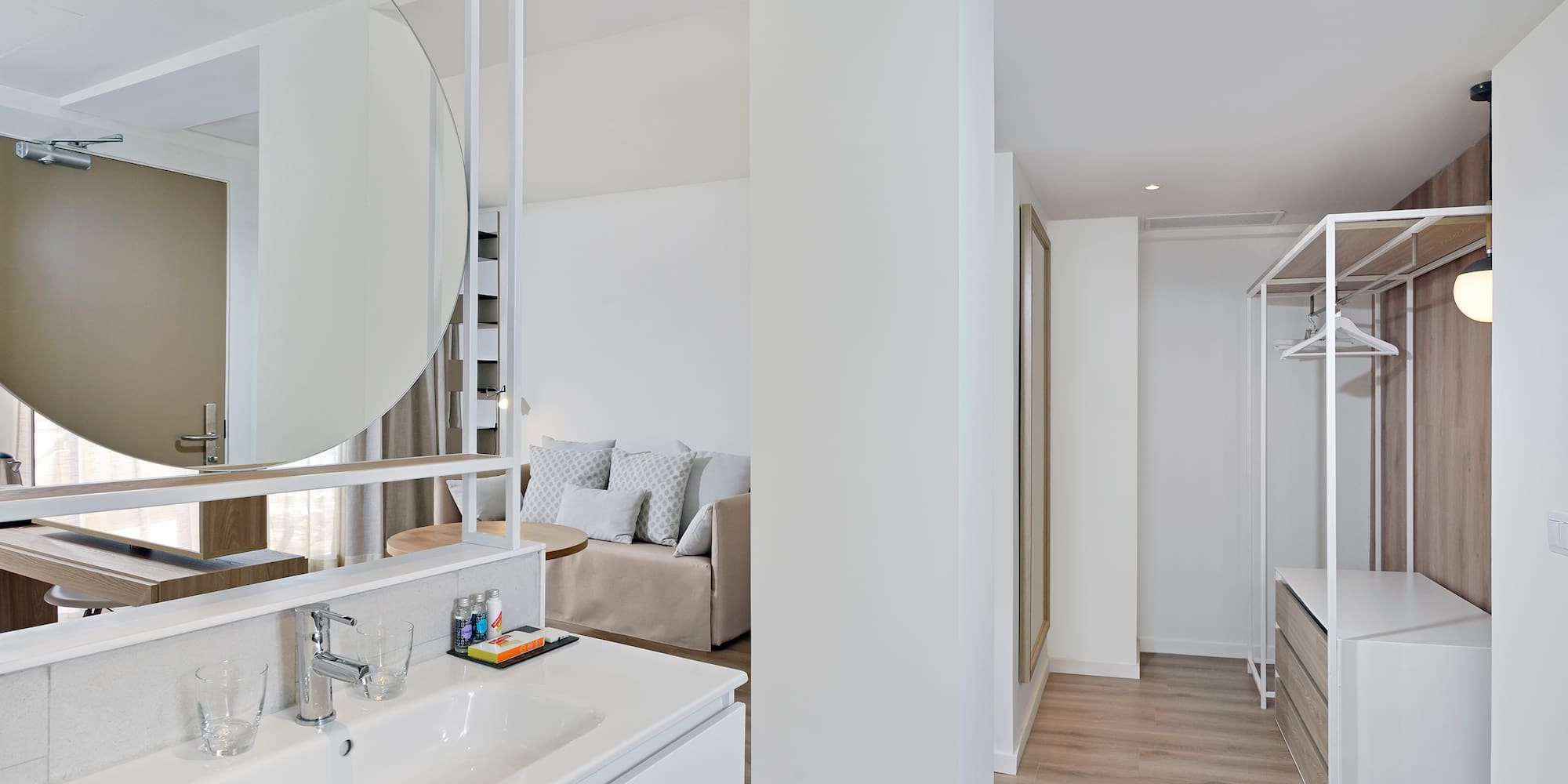 Modern open-plan suite with bathroom vanity, living area, and open closet.