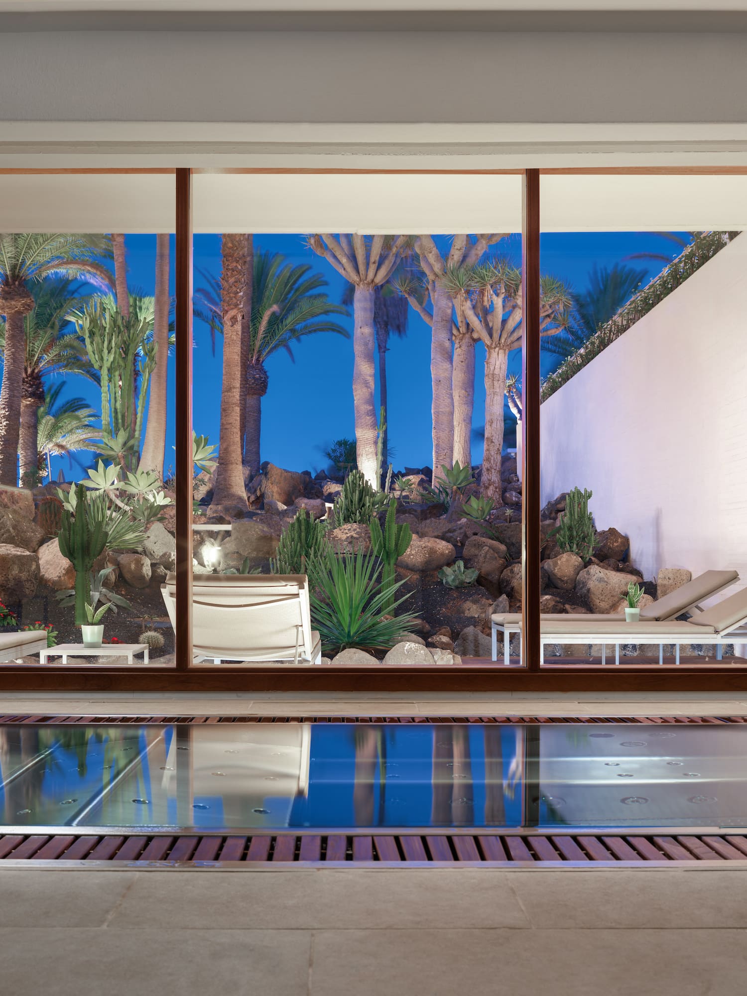 a pool with a view of a pool and chairs outside