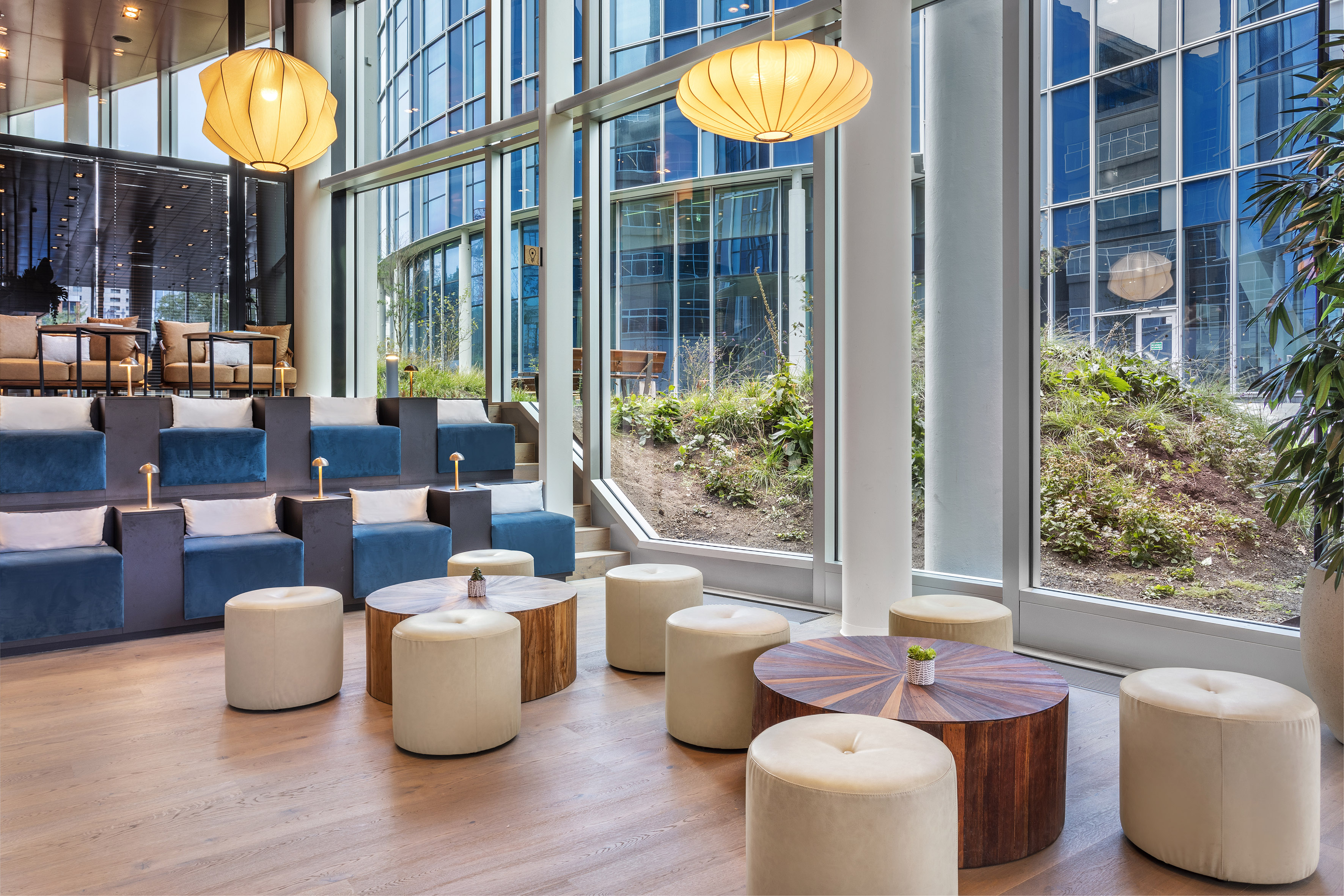 a room with large windows and tables and chairs