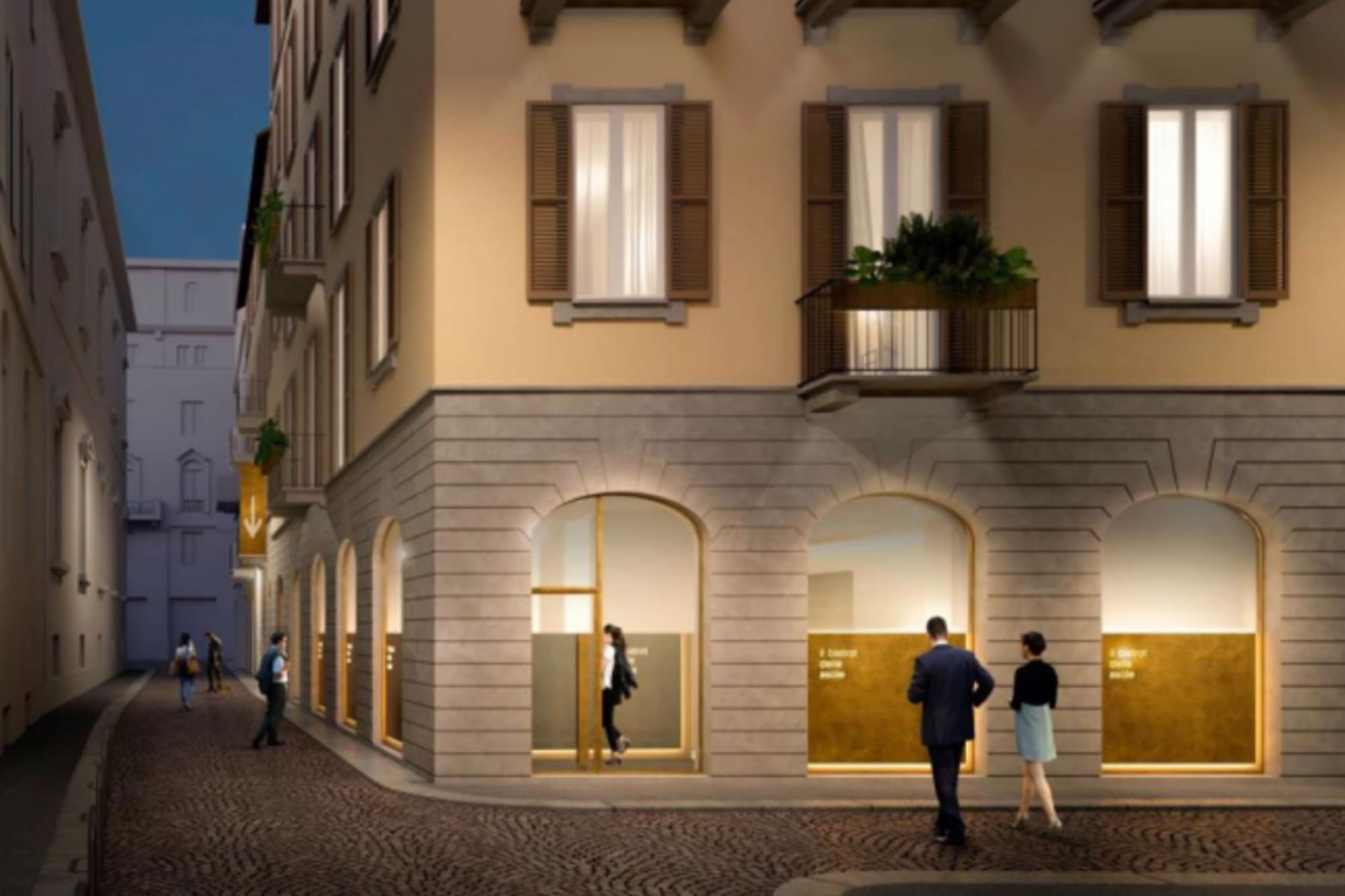Night street scene with people and a historic European building with shops.