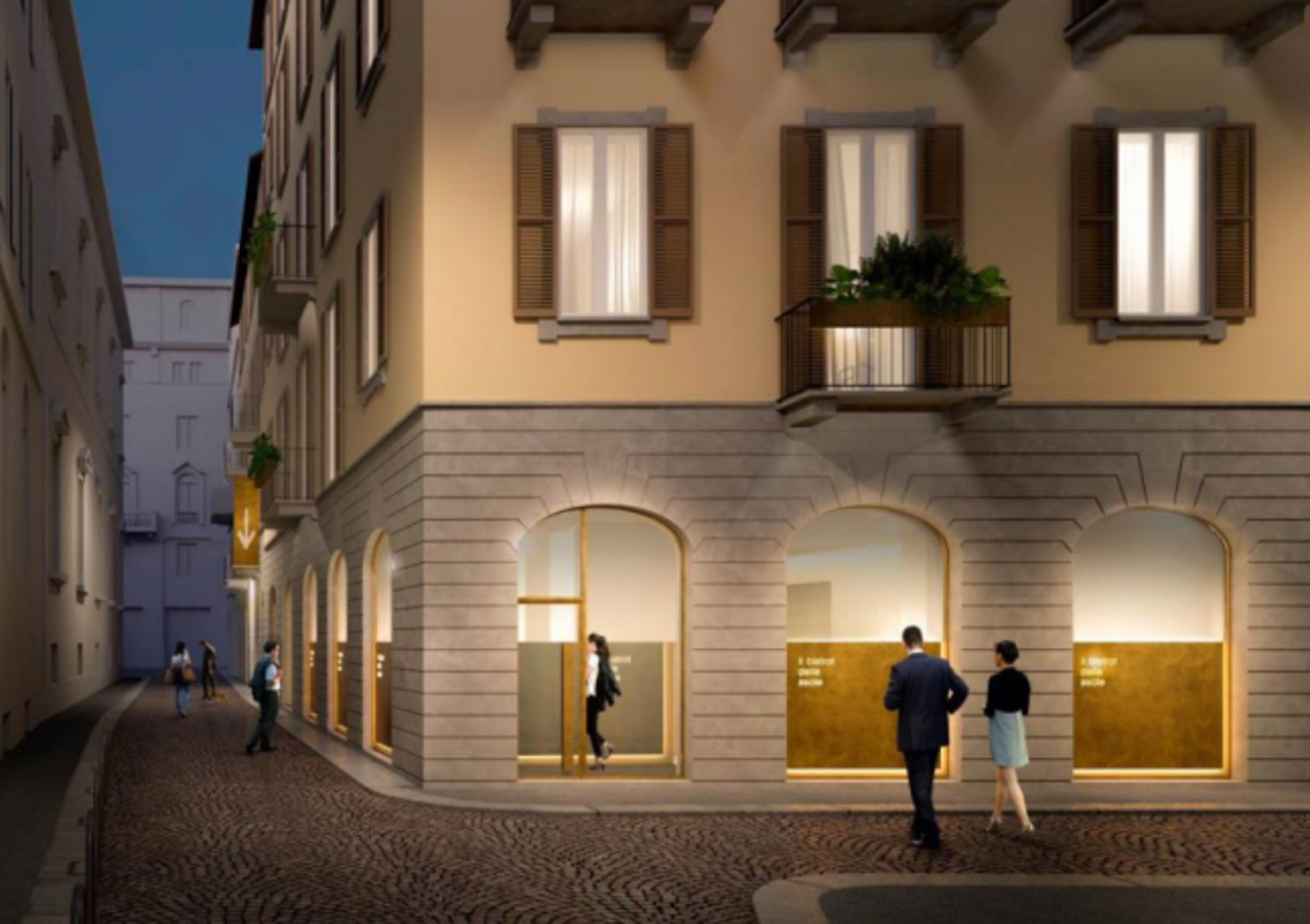 Night street scene with people and a historic European building with shops.