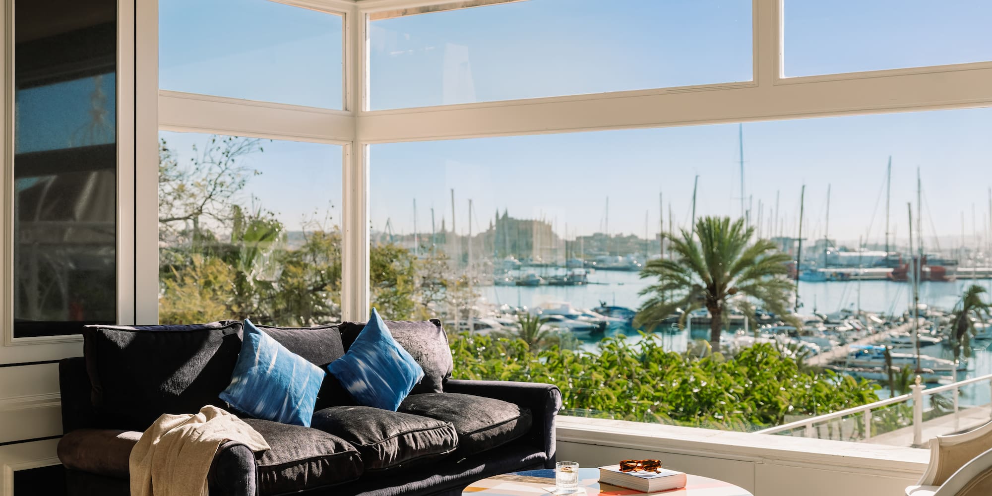 a living room with a couch and a table and a view of boats and water