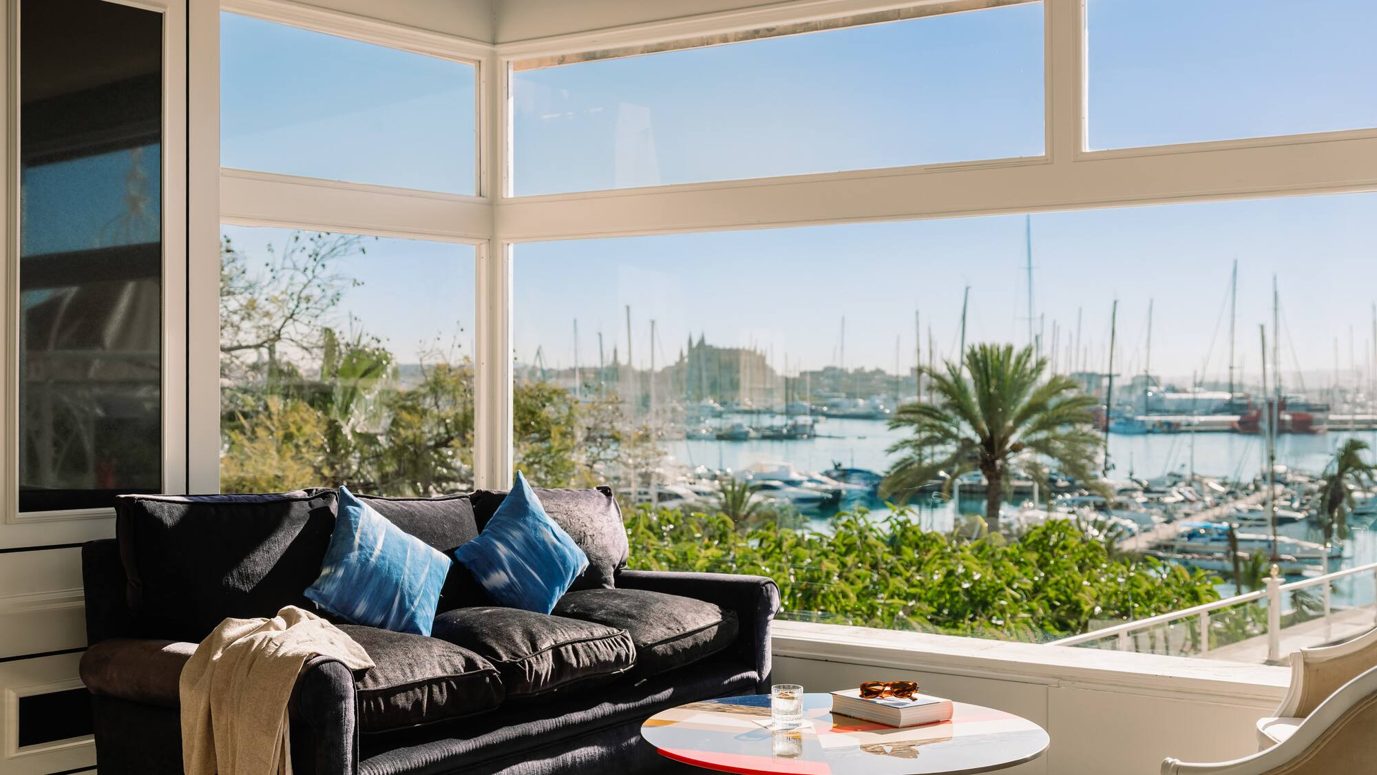 a living room with a couch and a table and a view of boats and water