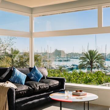 a living room with a couch and a table and a view of boats and water
