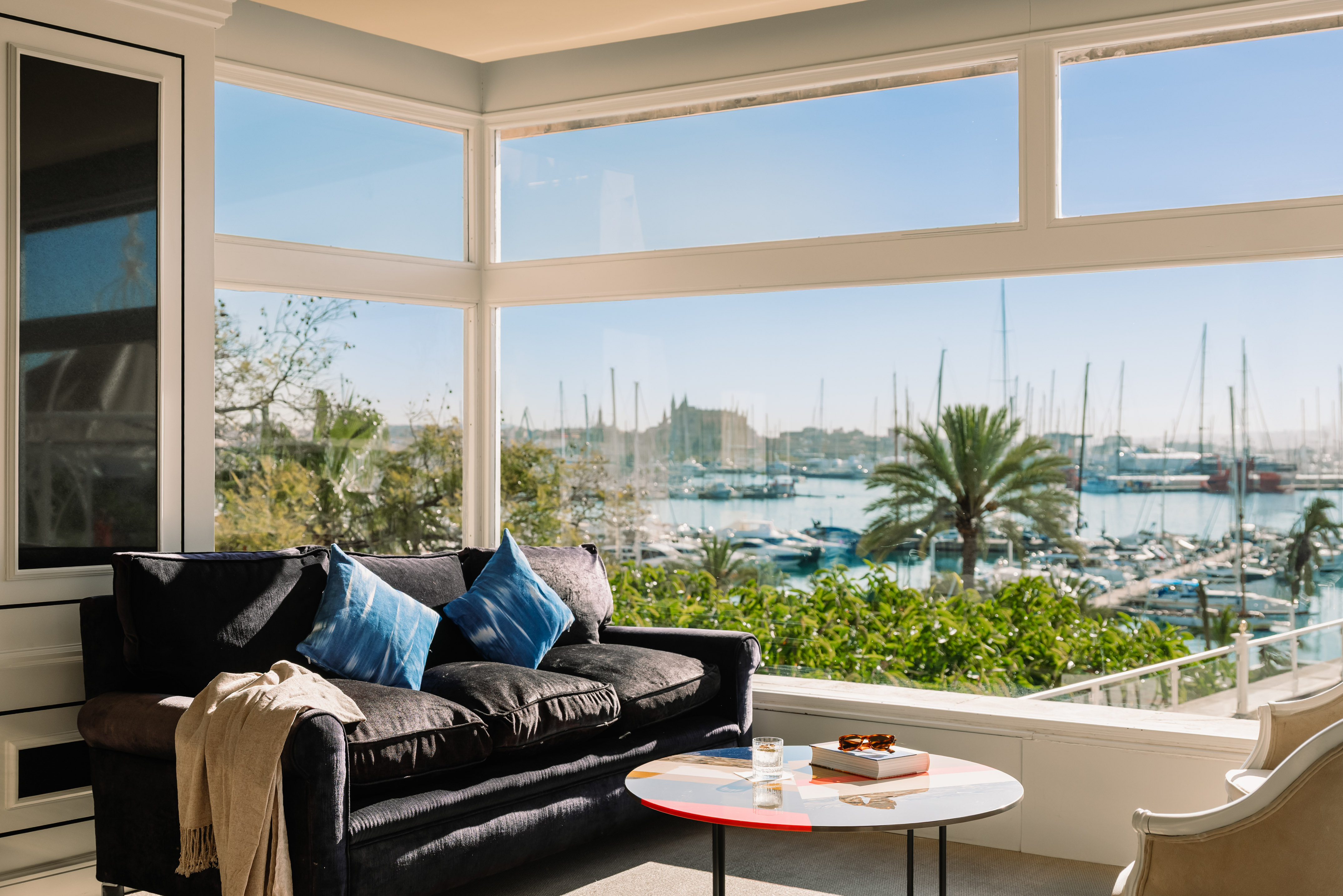 a living room with a couch and a table and a view of boats and water