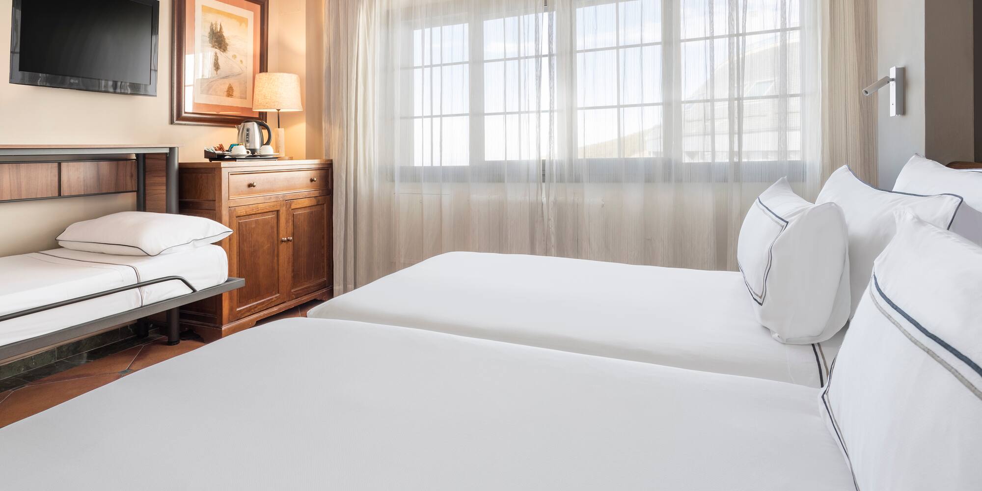 a room with two beds and a window