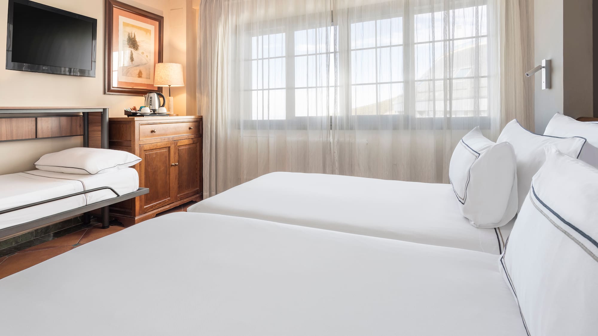 a room with two beds and a window