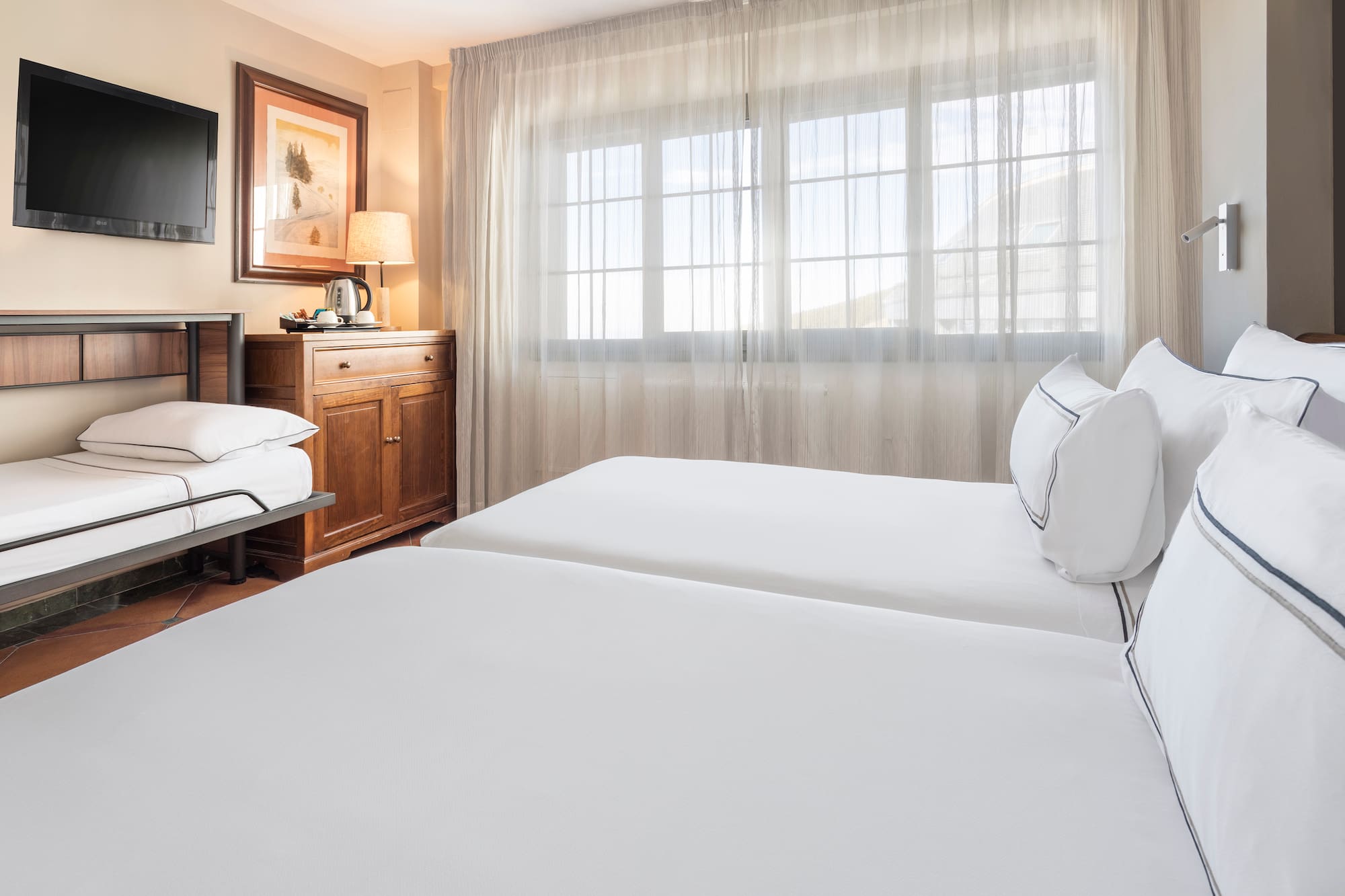 a room with two beds and a window