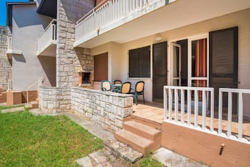 a patio with chairs and a stone wall