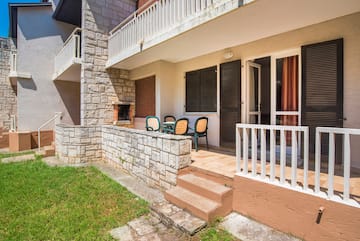 a patio with chairs and a stone wall