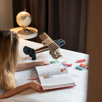 a woman lying on a bed reading a book