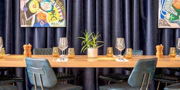 a table with wine glasses and a painting on the wall