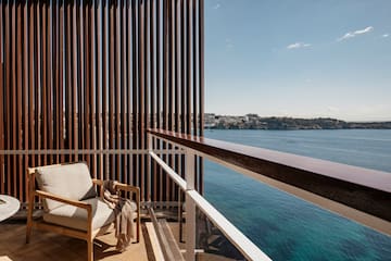 a chair on a balcony overlooking water