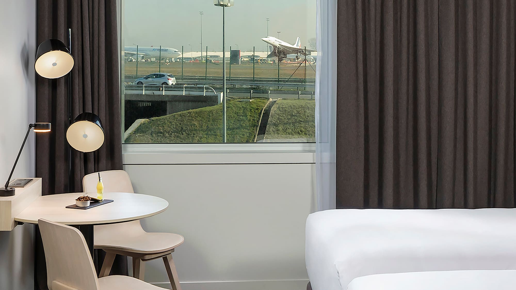 a room with two beds and a table and chairs