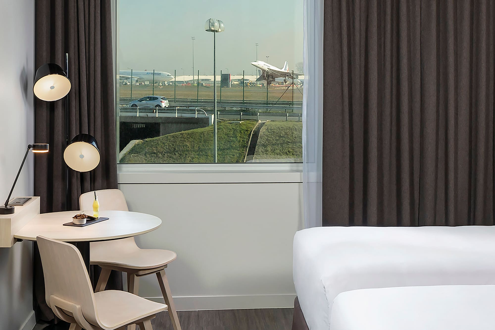 a room with two beds and a table and chairs