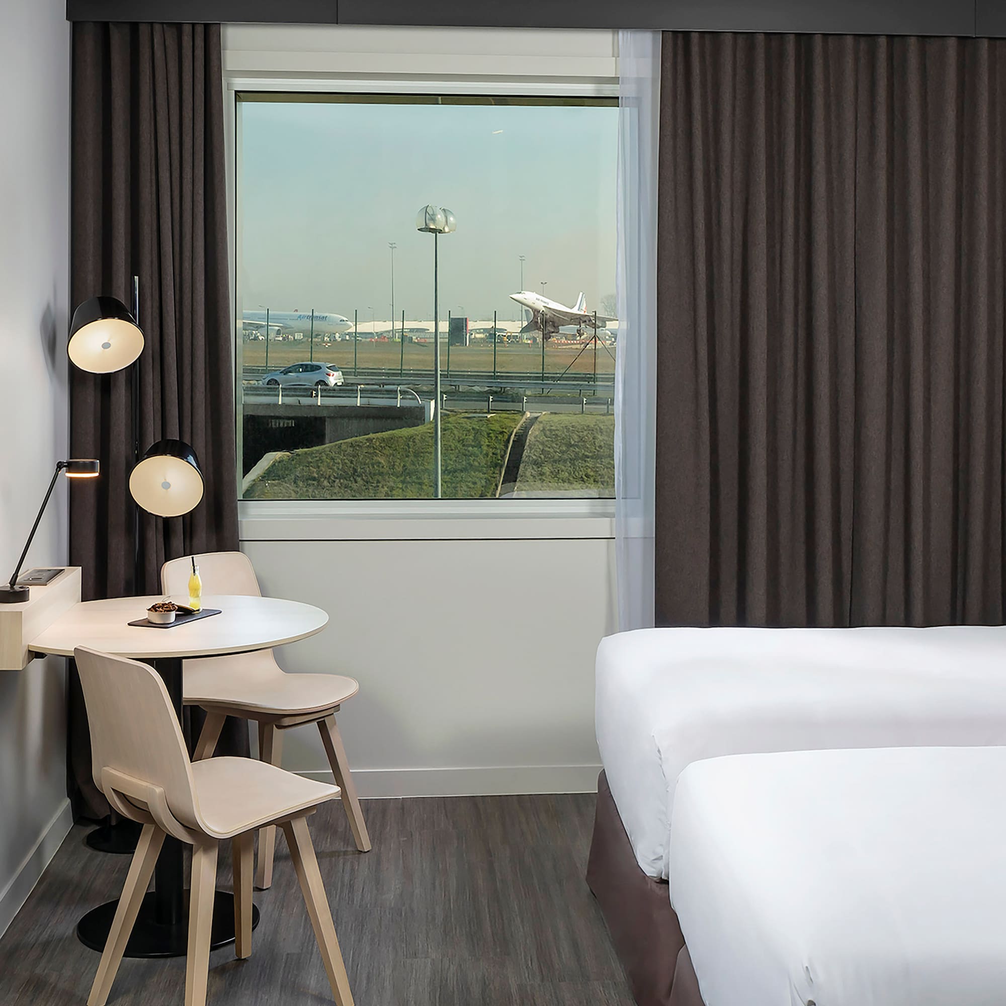 a room with two beds and a table and chairs