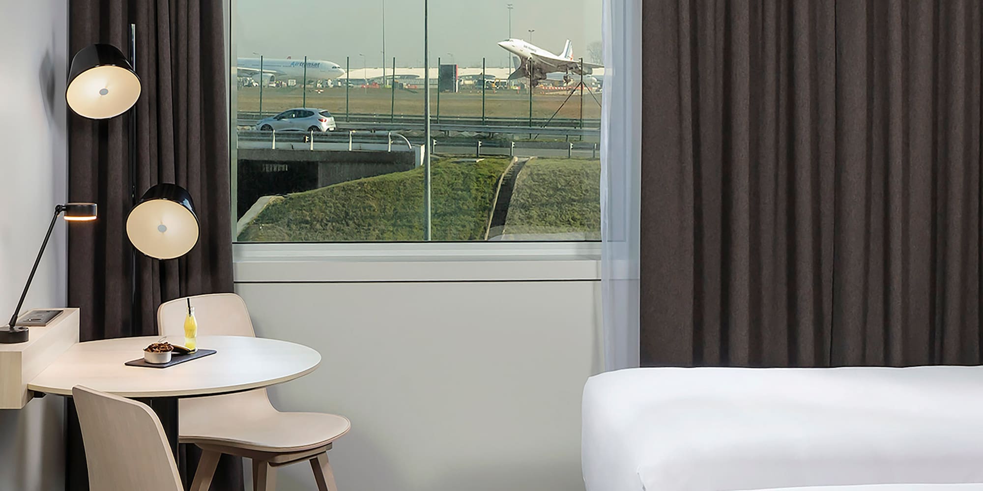 a room with two beds and a table and chairs