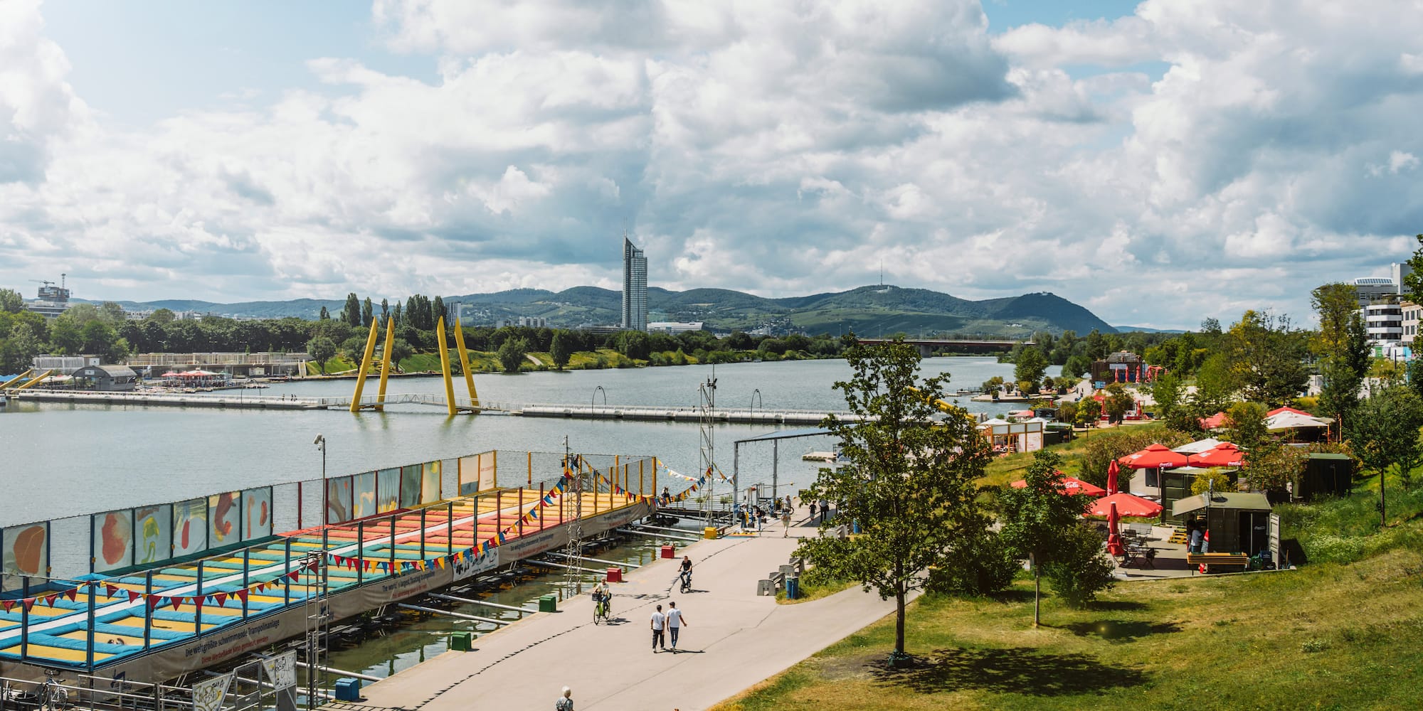a group of people walking on a path next to a body of water