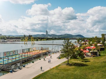a group of people walking on a path next to a body of water