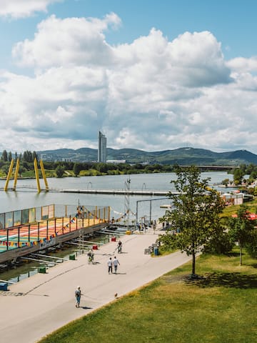 a group of people walking on a path next to a body of water