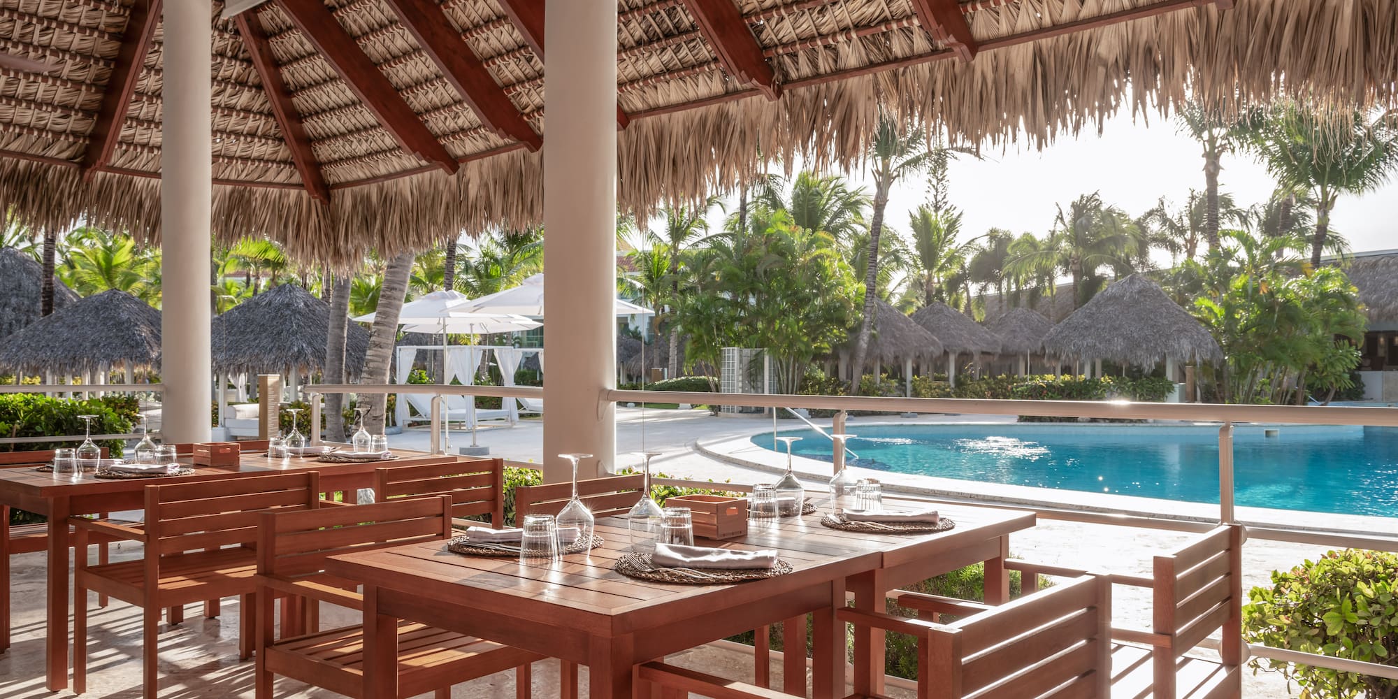 a table and chairs under a thatched roof