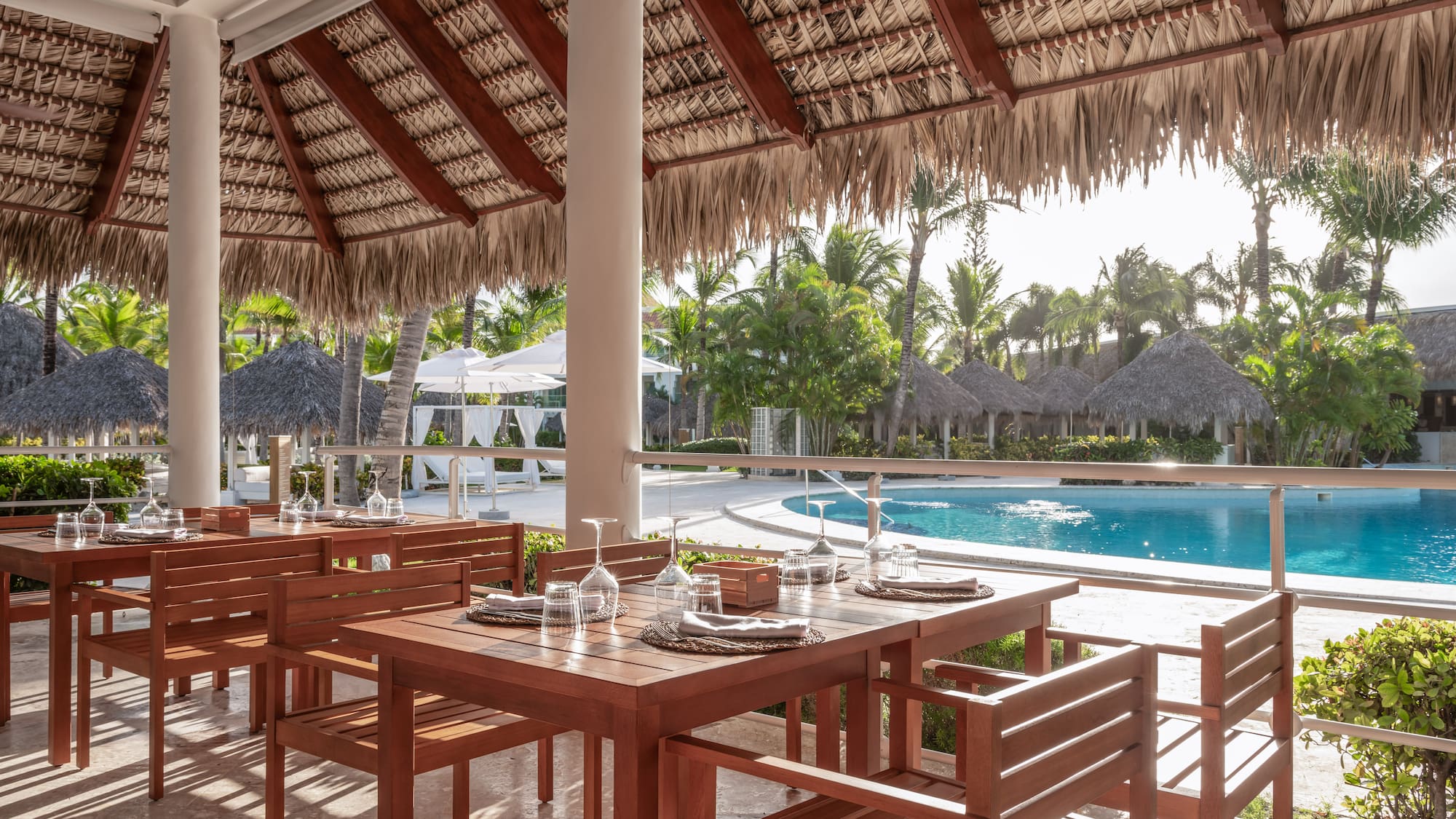 a table and chairs under a thatched roof