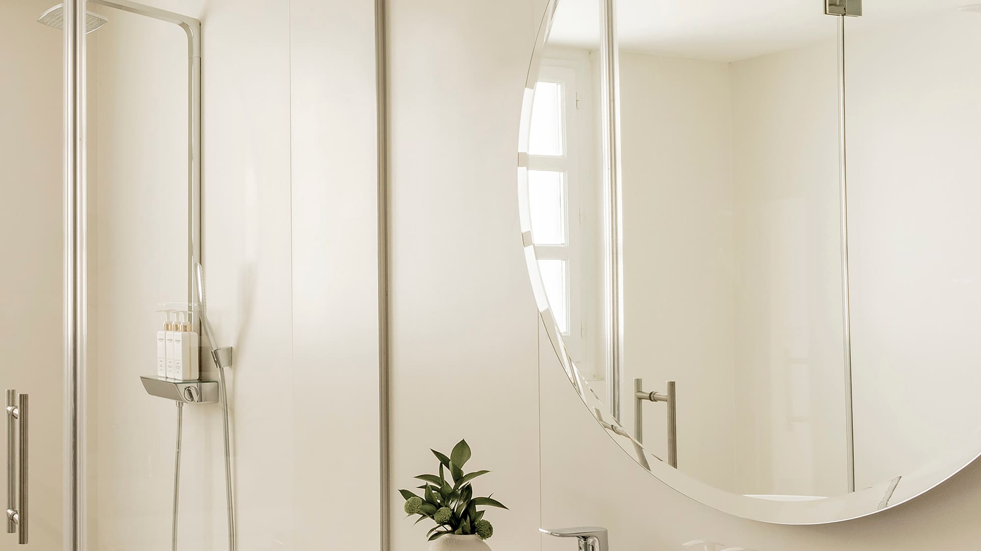 a bathroom with a large round mirror and sink