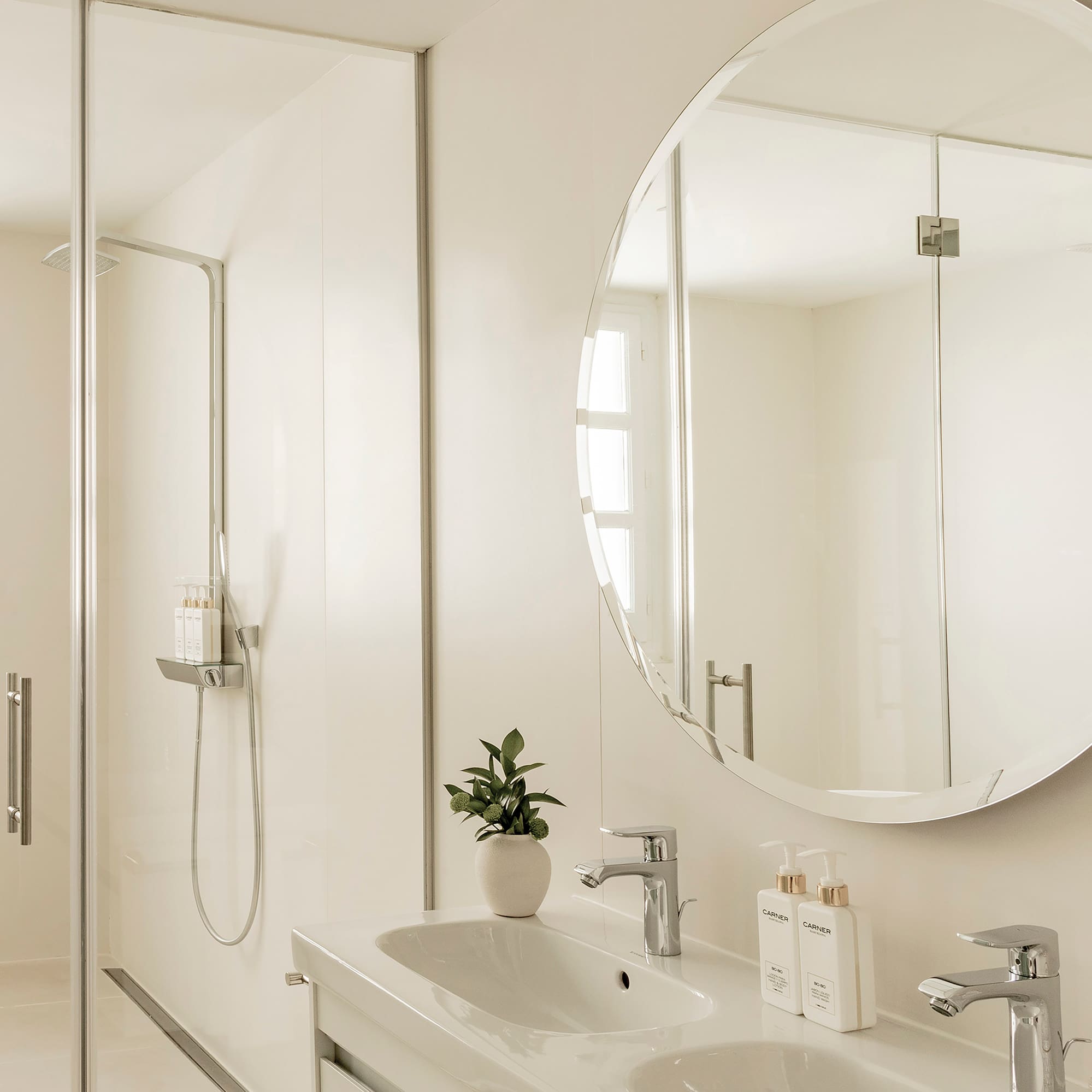 a bathroom with a large round mirror and sink