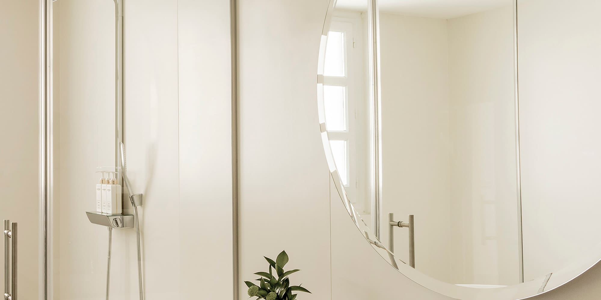 a bathroom with a large round mirror and sink
