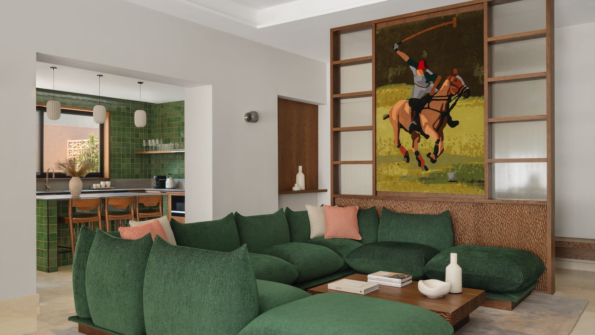 a living room with a large green couch and a painting of a polo player