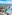 Tropical beachfront resort with large pool, palm trees, and ocean view.
