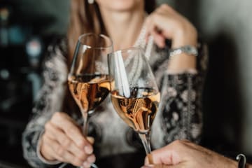 a woman holding wine glasses