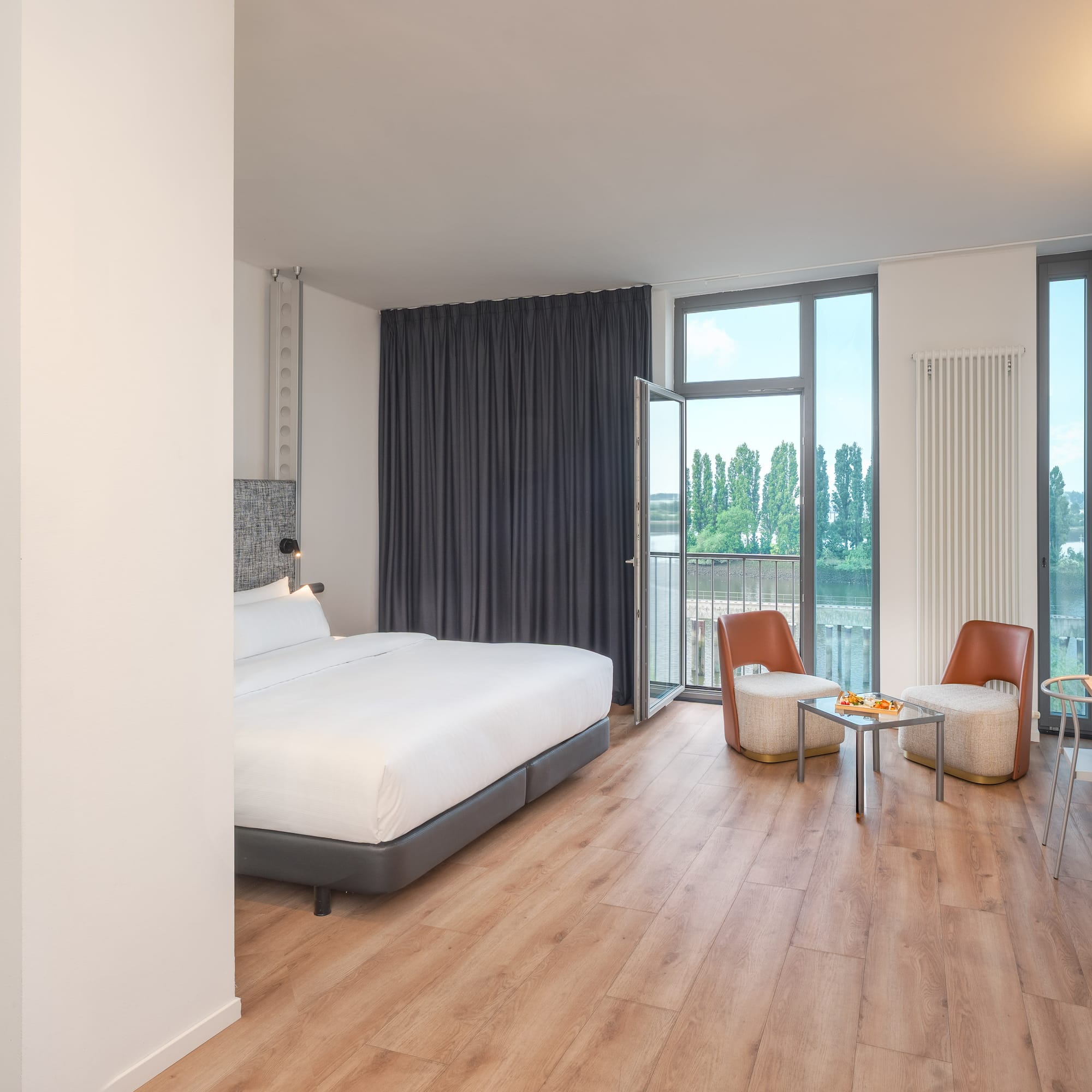 a room with a bed and chairs