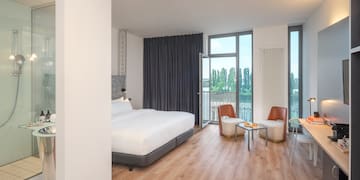 a room with a bed and chairs