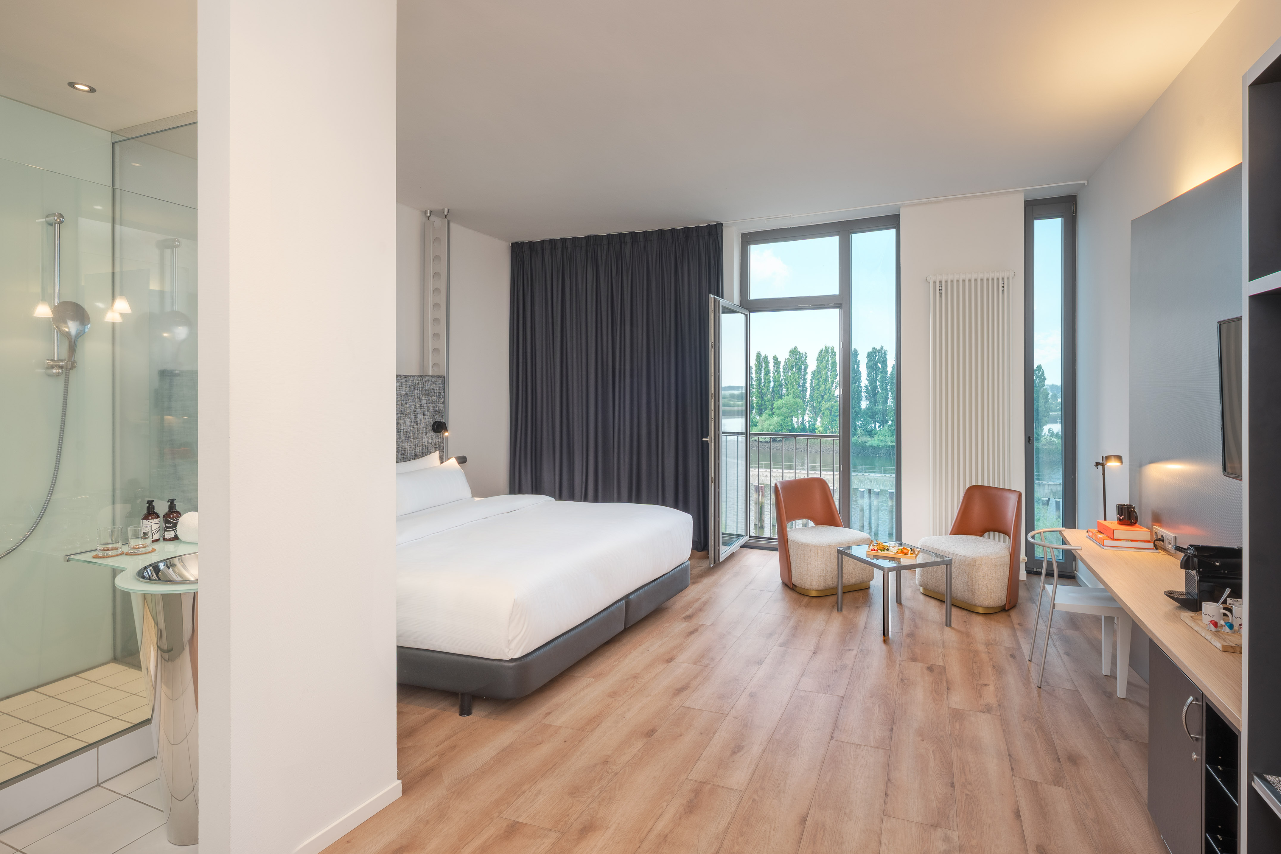 a room with a bed and chairs