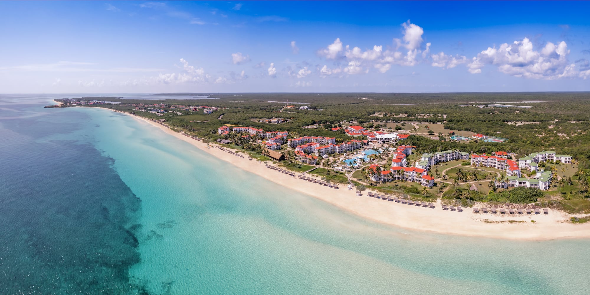a beach with buildings and a body of water