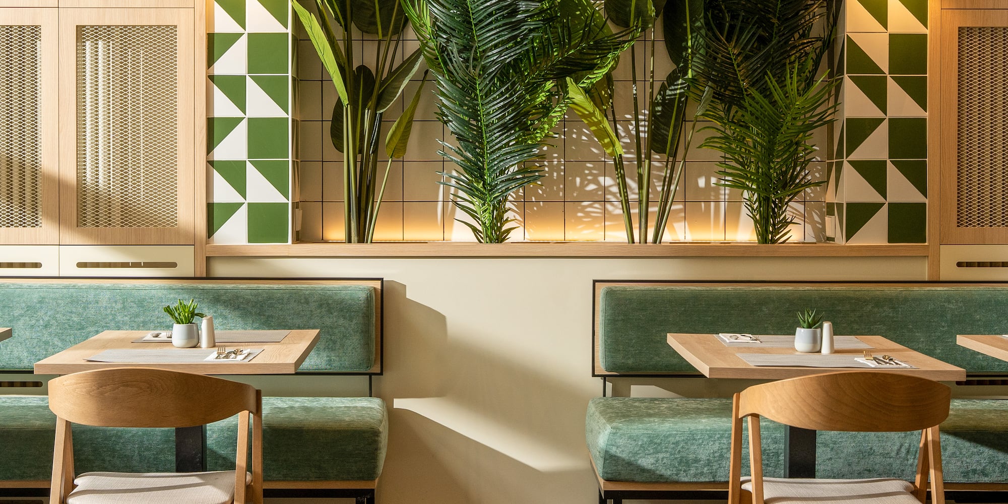 a room with green benches and tables and plants