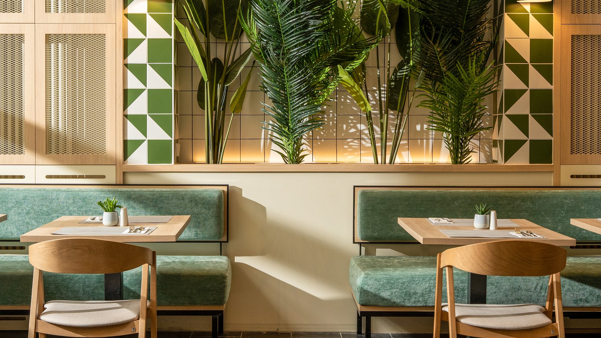 a room with green benches and tables and plants
