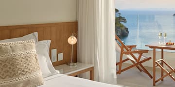 uma cama com uma mesa e uma lâmpada ao lado de uma cadeira de praia