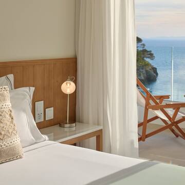 a bed with a table and a lamp next to a beach chair