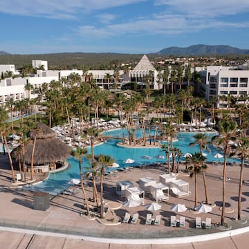 a pool with palm trees and a building in the background