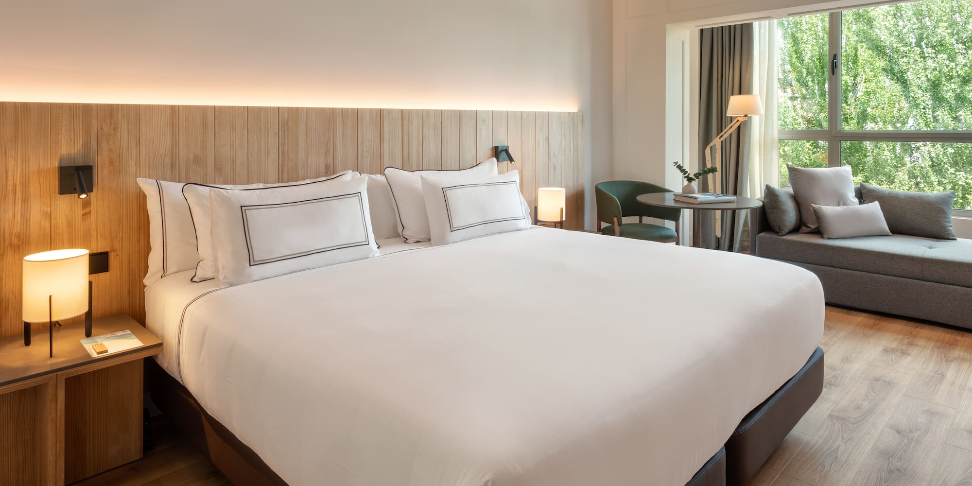 a bed with white sheets and a wood headboard in a hotel room