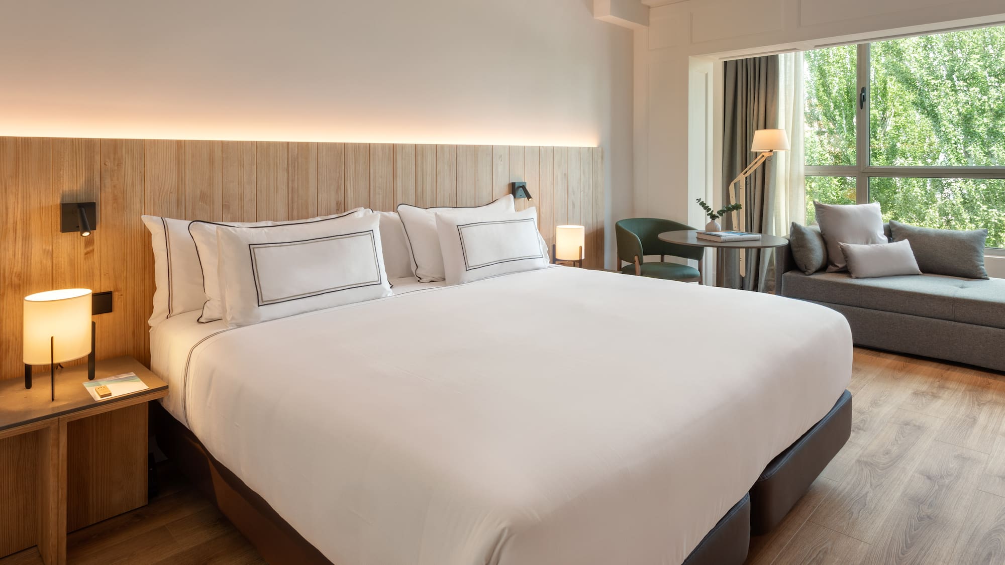 a bed with white sheets and a wood headboard in a hotel room