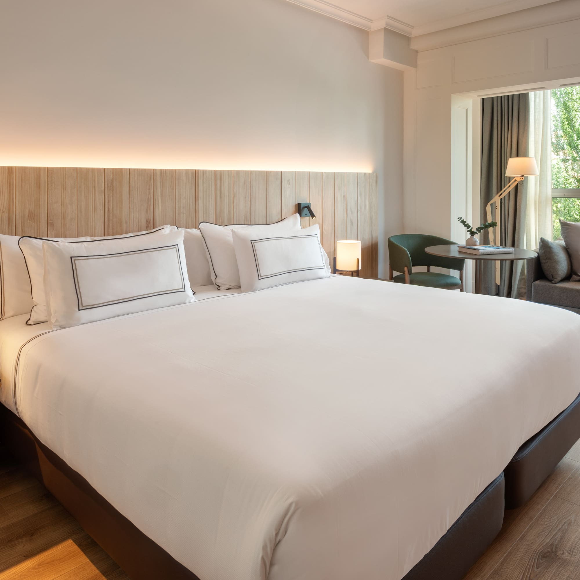 a bed with white sheets and a wood headboard in a hotel room