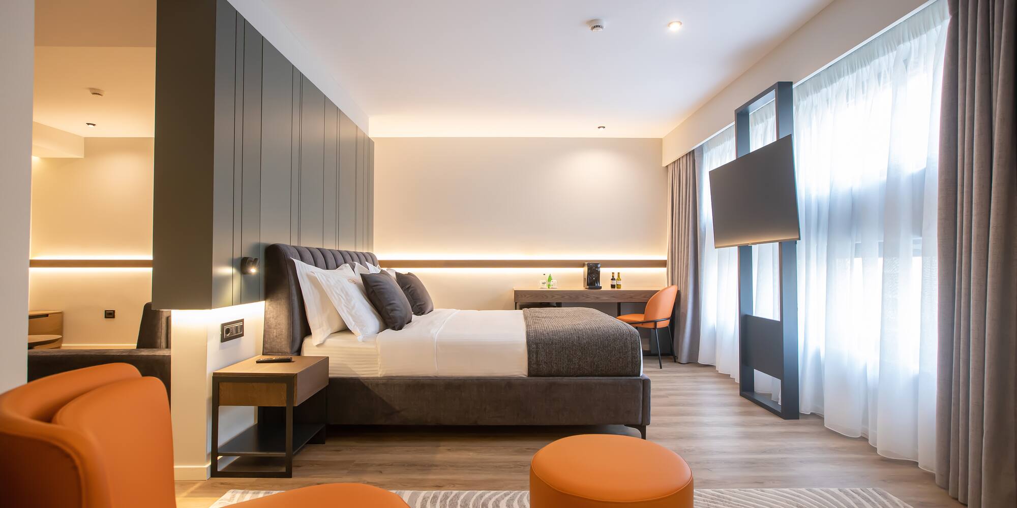 a room with a bed and orange chairs